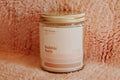 Picture of a glass jar Bubble Bath candle on a retro pink bathmat.