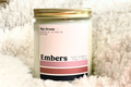 Candle labeled "Embers" placed on a cozy sherpa background.