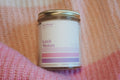 A clear glass jar with a label that reads 'Love Notes' in a pink knitted Valentine's Day fabric background.