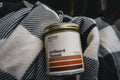 Candle labeled 'Orchard Donut' on a flannel background